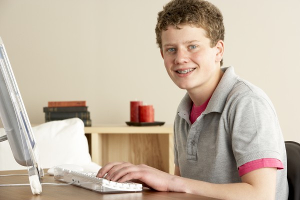 smiling teenage boy studying at home