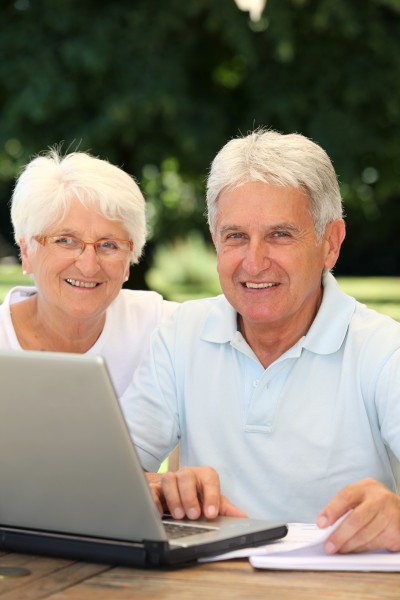 senior couple at home surfing on