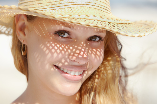 woman in straw hat smiling at
