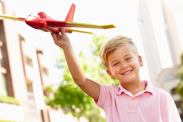 young boy outside with toy aeroplane