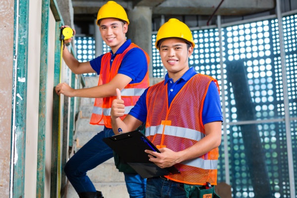 Asian worker controlling building on construction site - Stock Photo ...