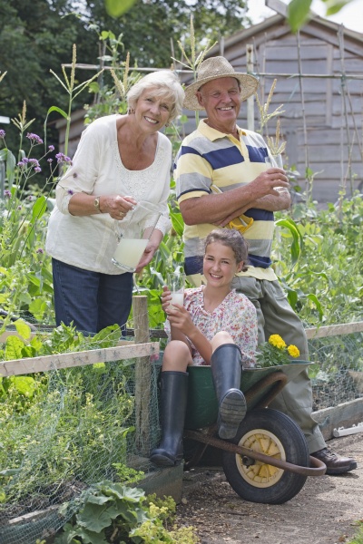 granddaughter sitting in garden wheelbarrow with