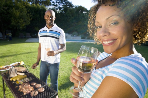 couple having barbeque outdoors woman