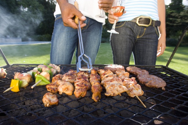 couple having barbeque outdoors standing