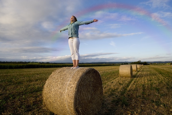 girl standing in hay bale