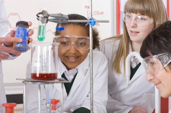 students watching chemistry teacher conduct experiment