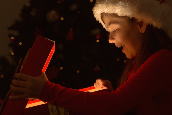 little girl opening a magical christmas