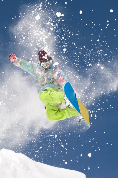 jumping snowboarder with clouds of snow