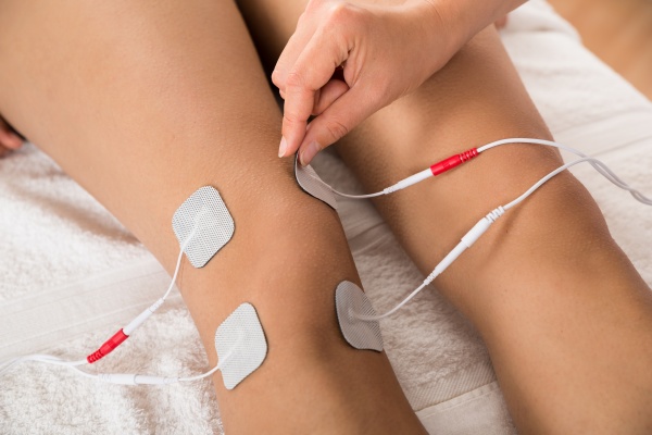 therapist placing electrodes on woman s