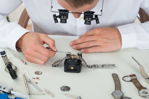man repairing wrist watch