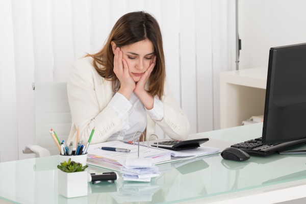 depressed businesswoman calculating invoice