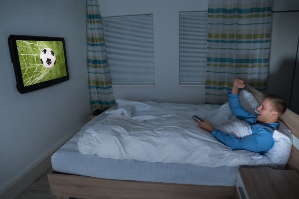 man watching football match on television