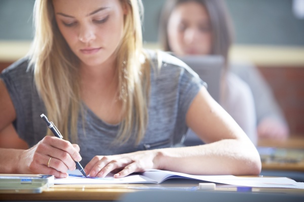 female student in classroom writing at