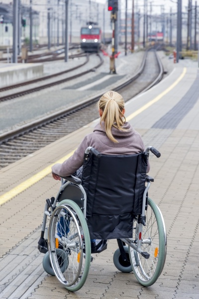 woman in wheelchair waiting at station