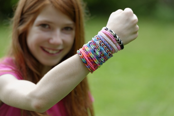 smiling girl showing self made looms