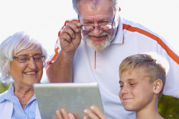 grandson and grandparents using digital tablet