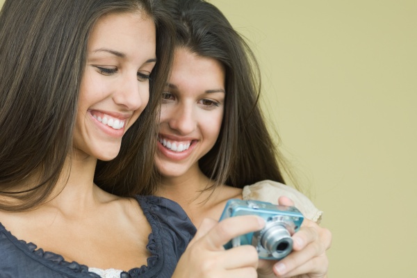 teenage twin sisters looking at digital