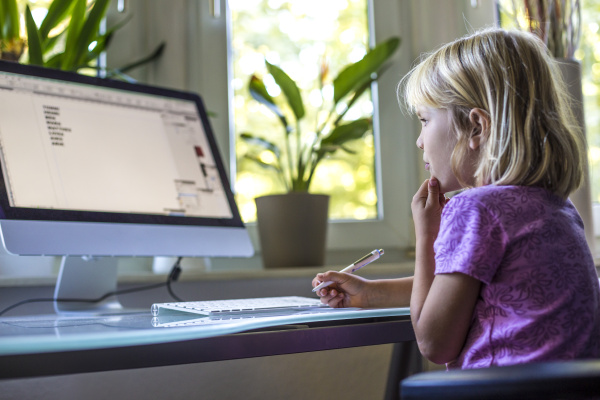 little girl looking at computer monitor