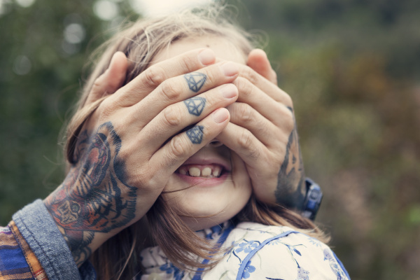 man s tattooed hands covering eyes