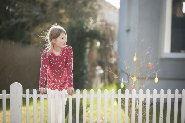 girl at garden fence glancing sideways