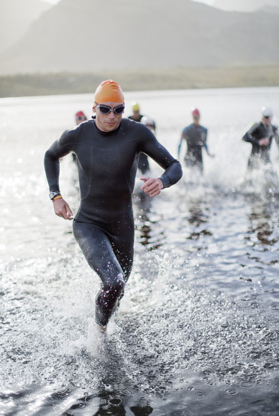 triathletes emerging from water