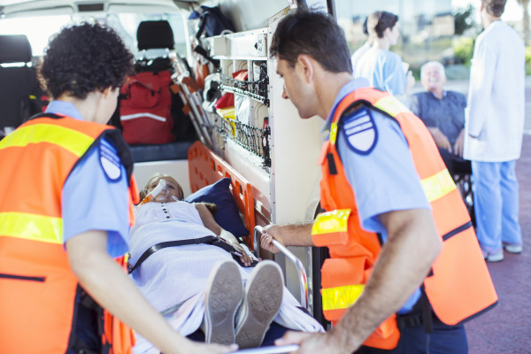 paramedics examining patient in ambulance