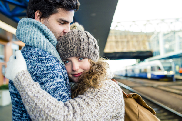 young couple embracing on station platform