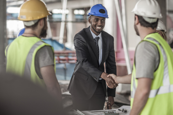 construction worker and executive shaking hands