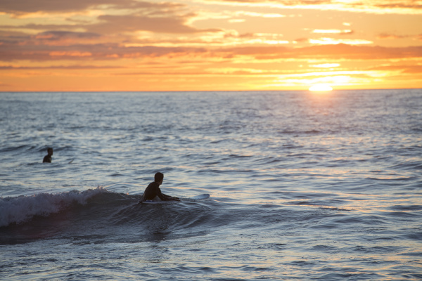 two surfers at sunrise