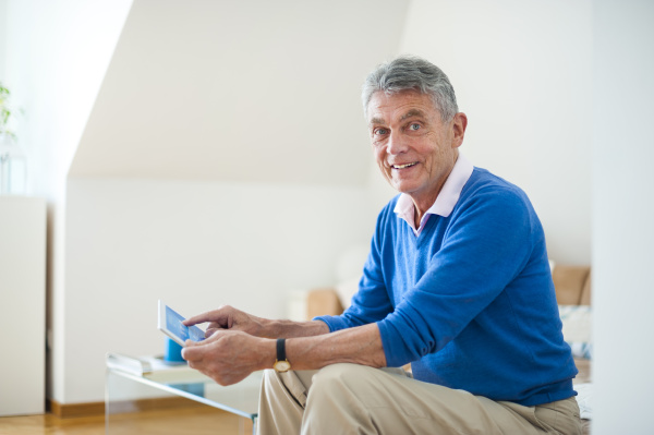 smiling senior man using digital tablet