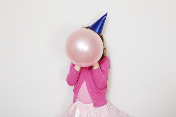girl holding pink balloon in front