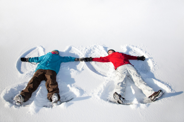 couple making snow angels outdoors