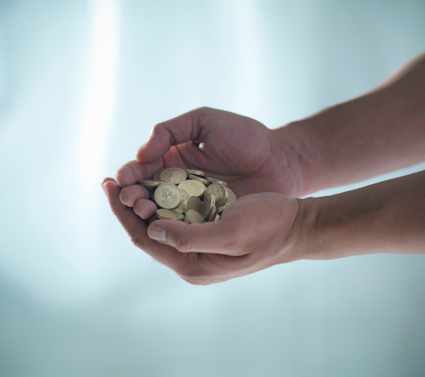 man with handful of pound coins