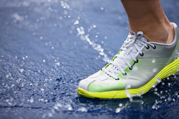 running shoe splashing water on track