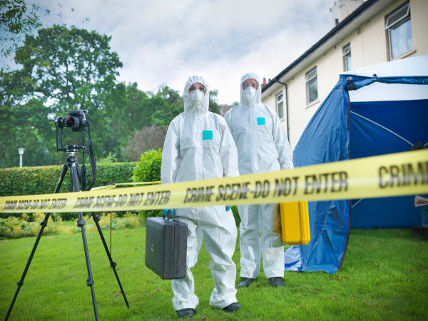 forensic scientists behind police tape at