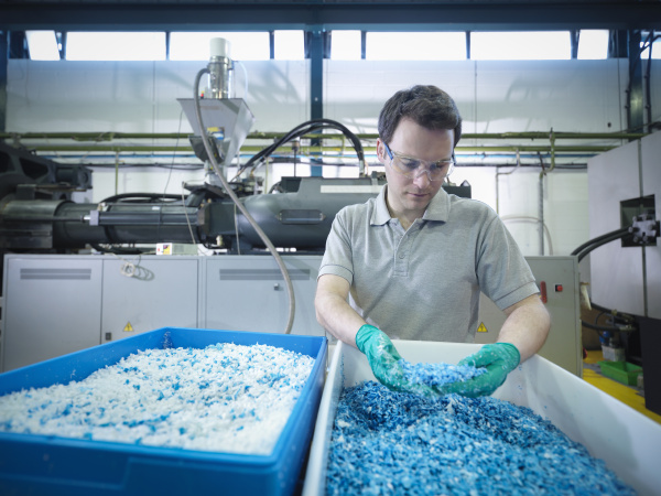 worker inspecting recycled plastic in plastics