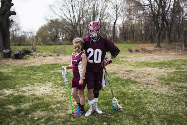 brother and sister wearing lacrosse uniforms