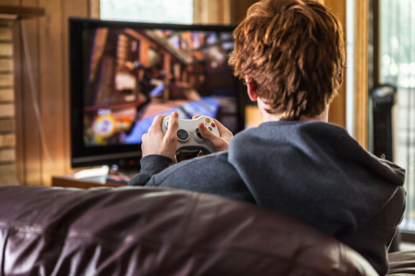 teenager playing video games at home
