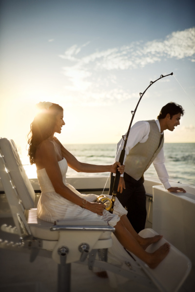 happy newlyweds fishing from a boat