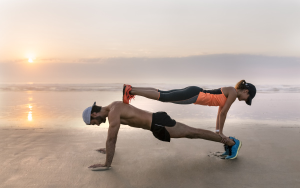 athletes couple training on the beach