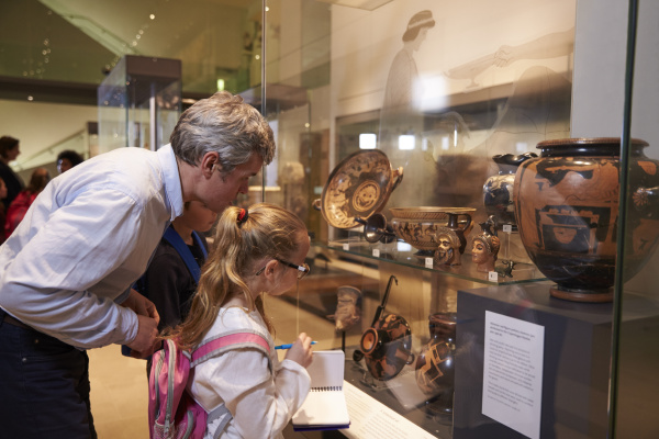 teacher-and-pupils-looking-at-artifacts-on-display-in-stock-image