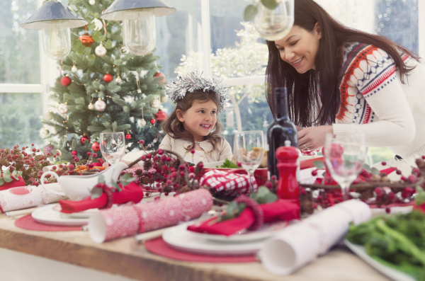 mother and daughter setting christmas table