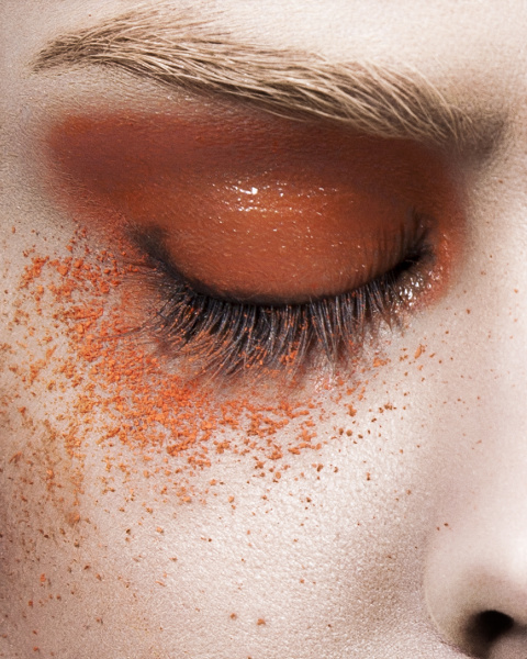 young woman with orange eye make