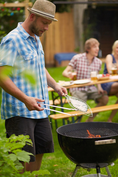 man grilling fish on barbecue outdoors