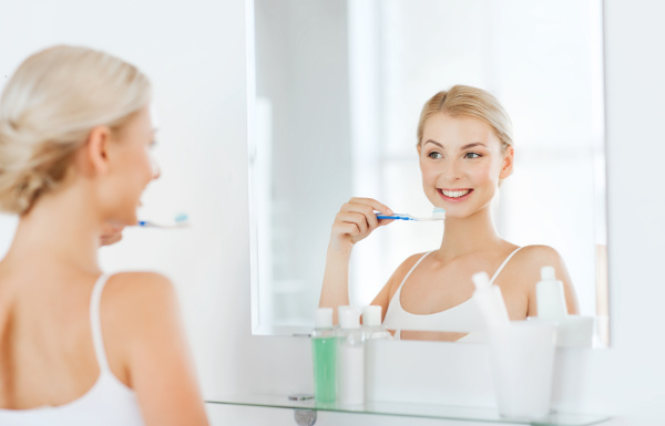 woman with toothbrush cleaning teeth at