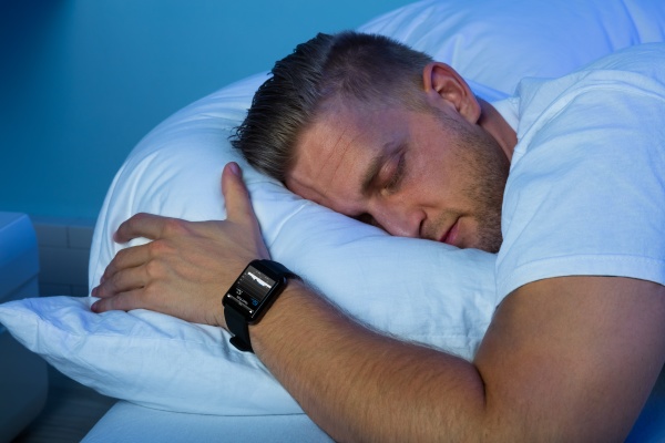 man-sleeping-with-smart-watch-in-his-hand-stock-photo-20211169