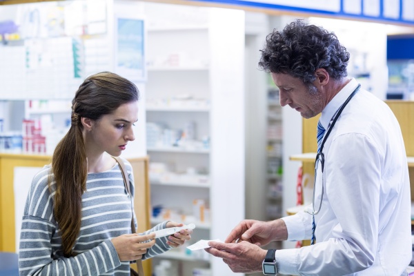 pharmacist explaining prescriptions to customer