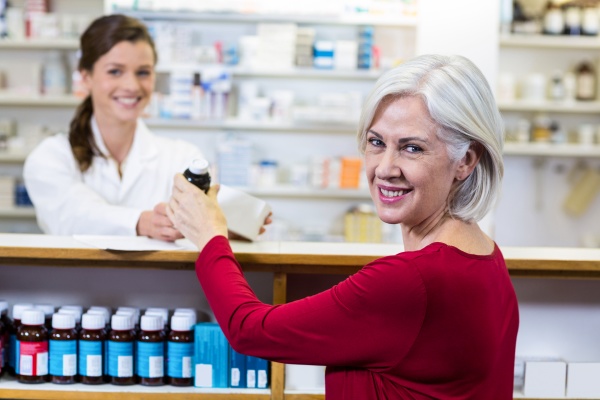 pharmacist giving medicine to customer in