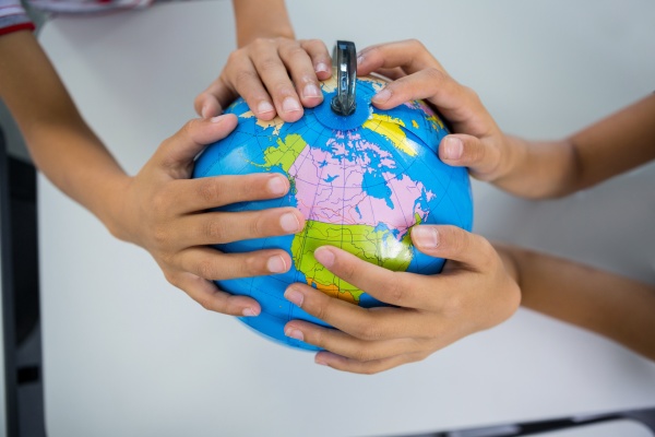 students holding globe in classroom