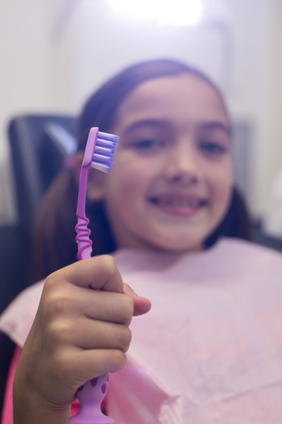 young patient holding her toothbrush